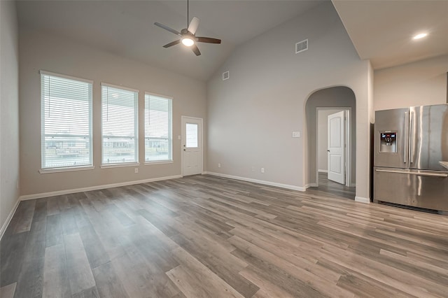 unfurnished living room featuring ceiling fan, light hardwood / wood-style floors, and high vaulted ceiling