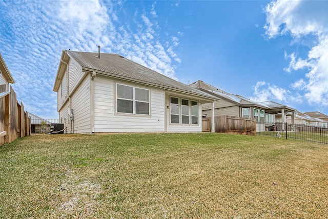 back of house featuring a lawn and central air condition unit