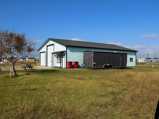 view of outdoor structure featuring a lawn and a garage