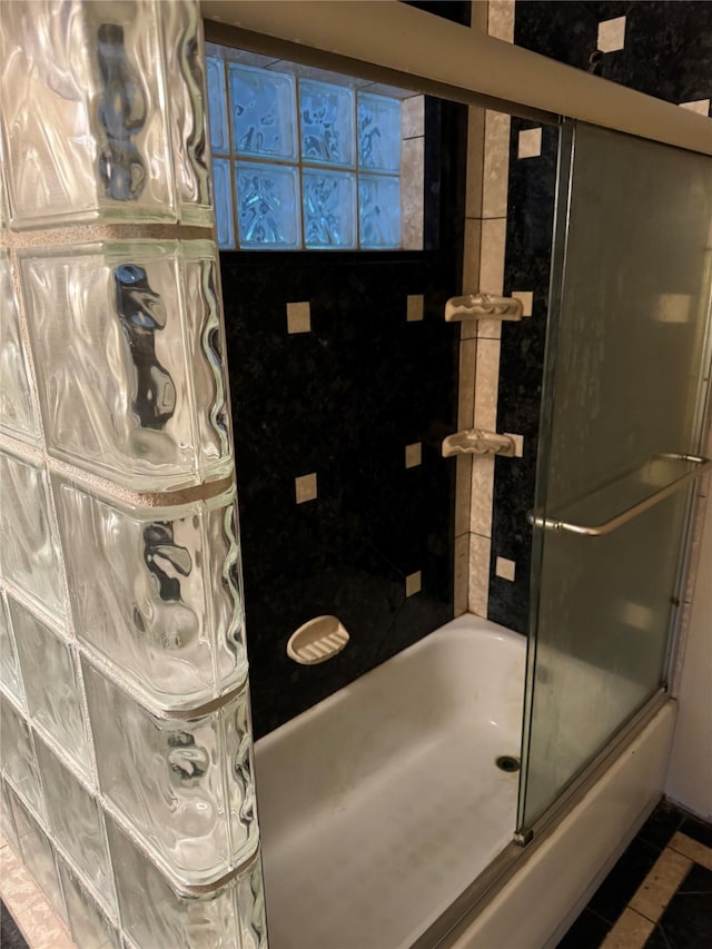 bathroom featuring tile patterned flooring and combined bath / shower with glass door