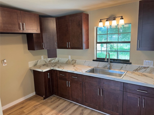 411 Lawrence Rd, Trinity, TX 75862 - kitchen featuring light wood finished floors, dark brown cabinetry, and light stone countertops