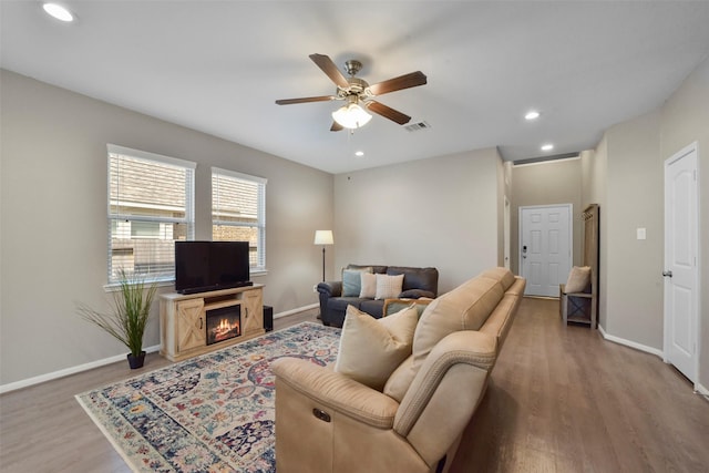 living room featuring wood-type flooring and ceiling fan