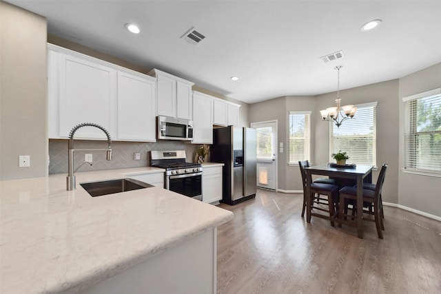 kitchen featuring a wealth of natural light, white cabinetry, sink, and appliances with stainless steel finishes