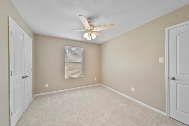 unfurnished bedroom with ceiling fan and light carpet