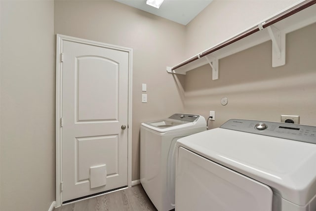 laundry room with washer and dryer and light wood-type flooring