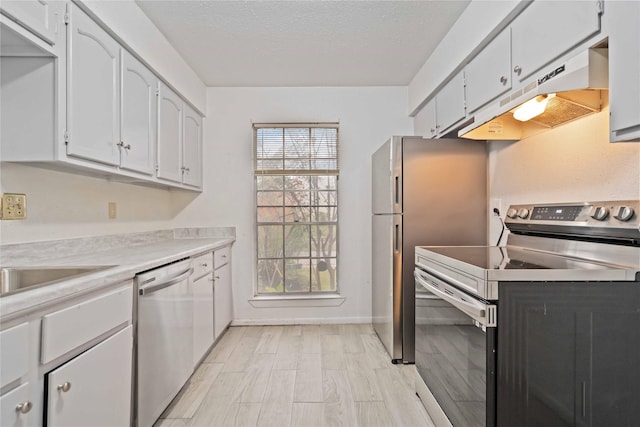 kitchen with white cabinets, stainless steel appliances, and a textured ceiling