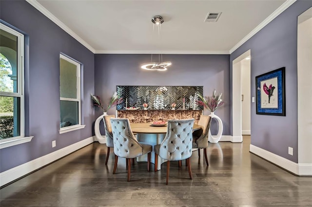 dining space with dark hardwood / wood-style floors, crown molding, and a notable chandelier