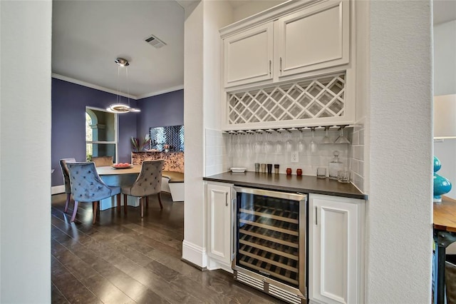 bar with beverage cooler, dark hardwood / wood-style flooring, backsplash, crown molding, and white cabinets