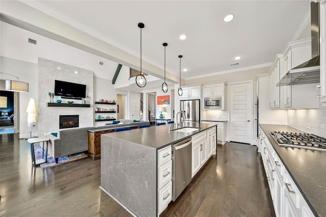 kitchen with beam ceiling, white cabinets, pendant lighting, and stainless steel appliances