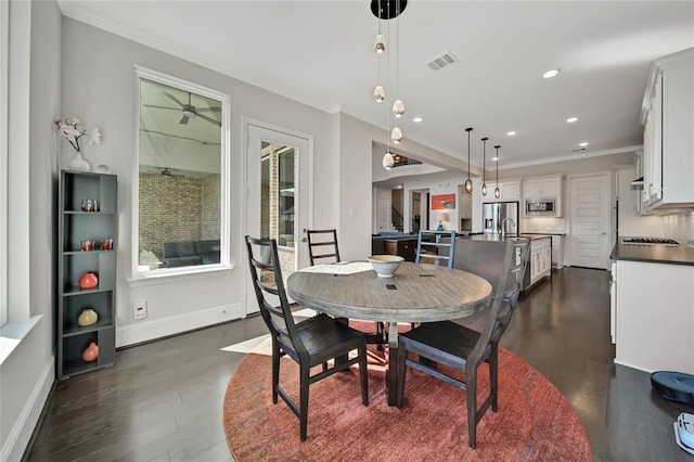 dining area with crown molding and dark wood-type flooring