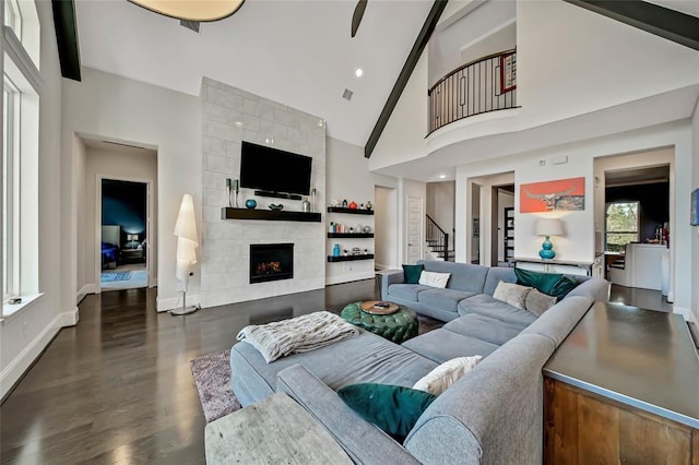 living room with a fireplace, dark wood-type flooring, and high vaulted ceiling