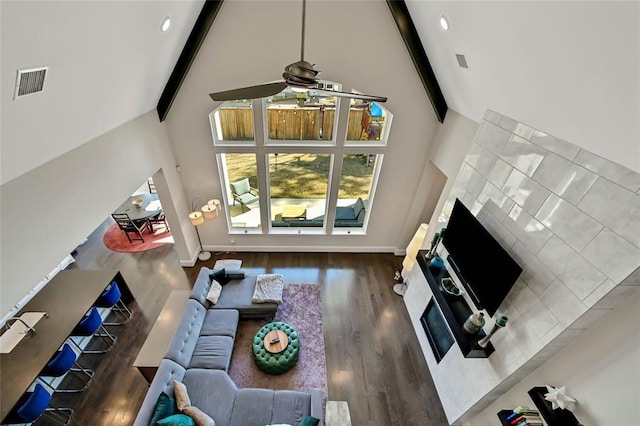 living room with hardwood / wood-style flooring, ceiling fan, beamed ceiling, and high vaulted ceiling