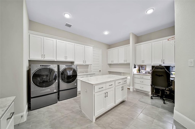 laundry area with cabinets, light tile patterned flooring, and washing machine and dryer