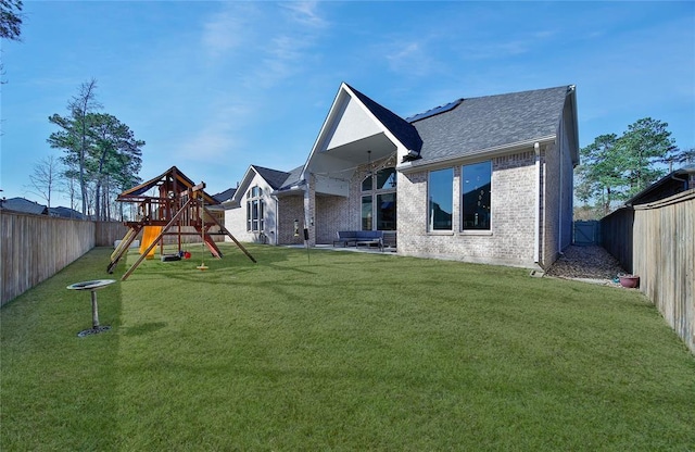 rear view of property with a lawn and a playground