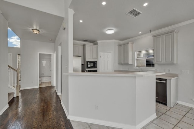 kitchen with gray cabinetry, stainless steel appliances, kitchen peninsula, crown molding, and light wood-type flooring