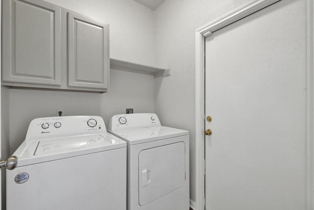 washroom featuring washer and dryer and cabinets