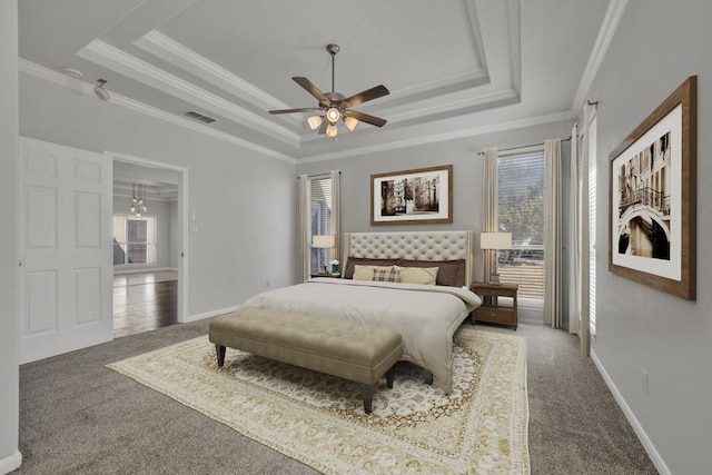 carpeted bedroom featuring a raised ceiling, ceiling fan, and ornamental molding