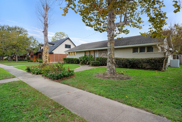 ranch-style house with a front yard and cooling unit