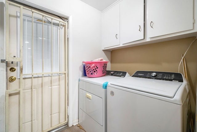 clothes washing area with cabinets and independent washer and dryer