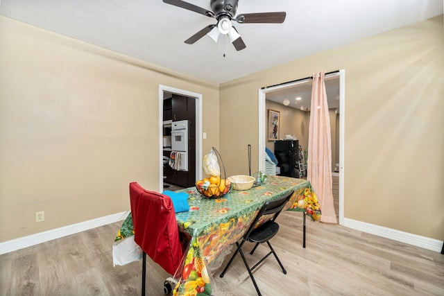 dining room with ceiling fan and light hardwood / wood-style floors