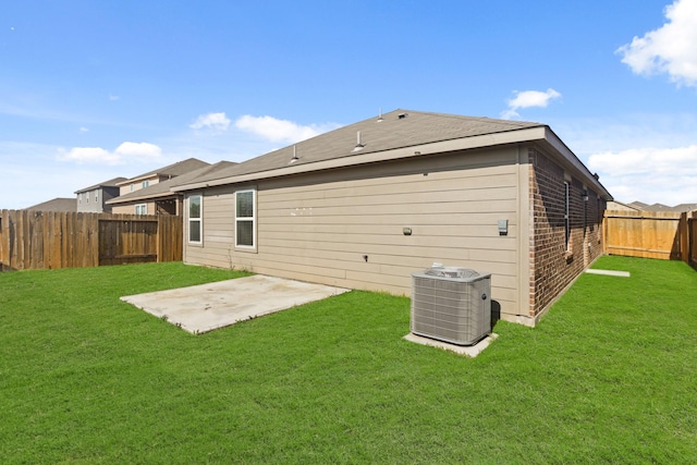 rear view of house featuring a yard, central AC, and a patio area