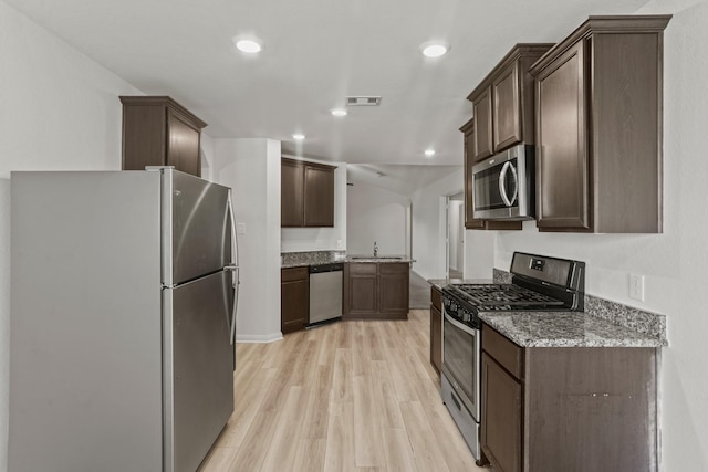 kitchen featuring appliances with stainless steel finishes, light wood-type flooring, dark brown cabinetry, and sink