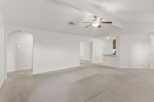 unfurnished living room featuring lofted ceiling with beams, ceiling fan, and light carpet