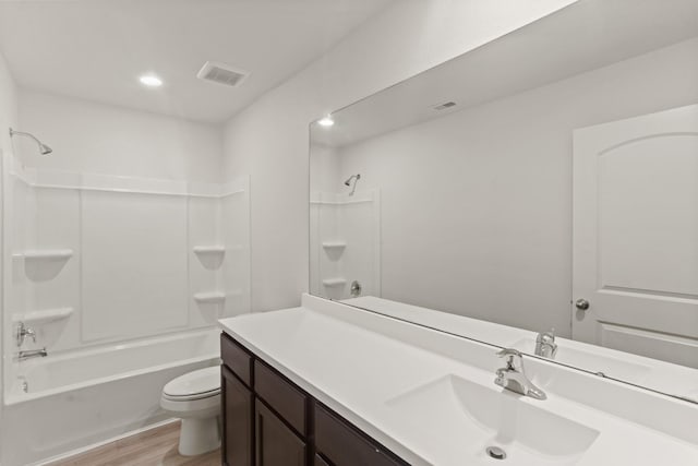 full bathroom with hardwood / wood-style floors, vanity, shower / bathtub combination, and toilet