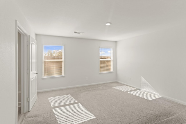 unfurnished room with a healthy amount of sunlight and light colored carpet