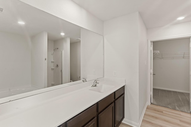 bathroom featuring vanity, hardwood / wood-style flooring, and walk in shower