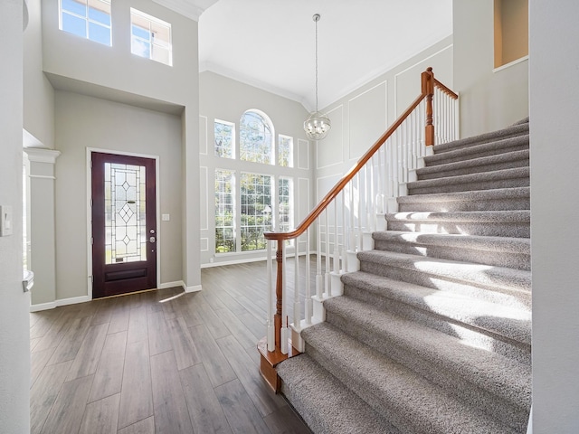 foyer featuring a chandelier, a high ceiling, dark hardwood / wood-style floors, and ornamental molding