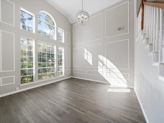 interior space with ornamental molding, dark wood-type flooring, and an inviting chandelier