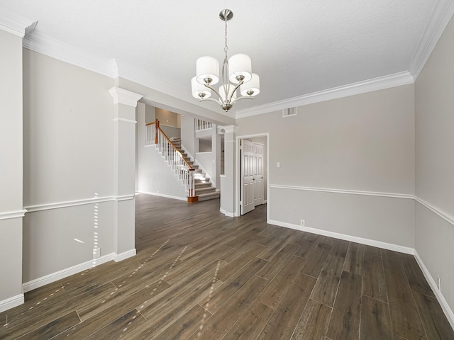 unfurnished dining area featuring a textured ceiling, dark wood-type flooring, a notable chandelier, and ornamental molding