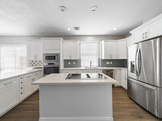 kitchen featuring sink, a kitchen island, stainless steel appliances, and dark hardwood / wood-style floors