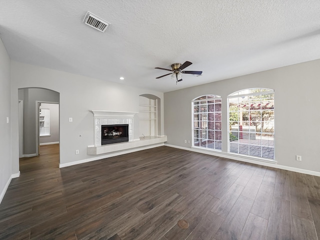 unfurnished living room with ceiling fan, dark wood-type flooring, and a textured ceiling