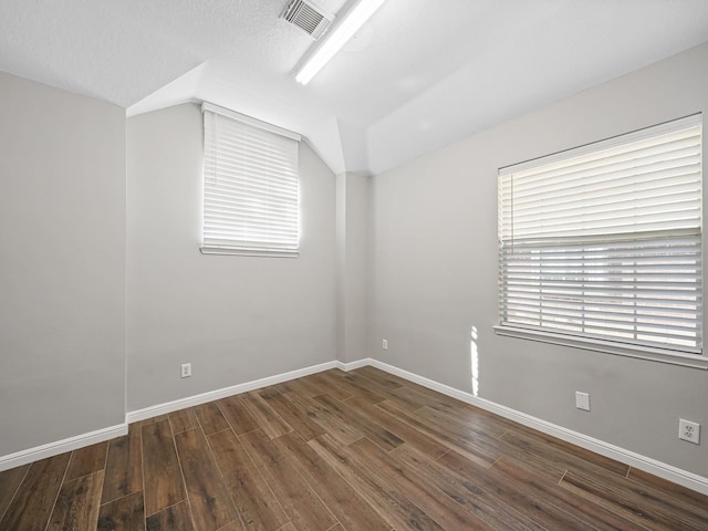 bonus room with a textured ceiling and dark hardwood / wood-style flooring