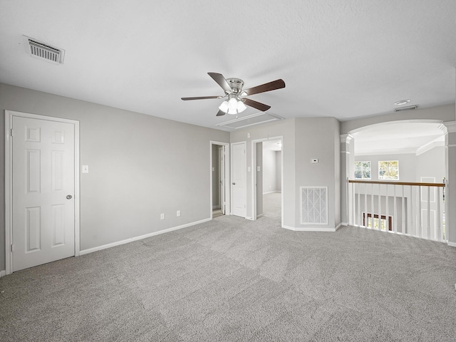 carpeted empty room with ceiling fan and a textured ceiling