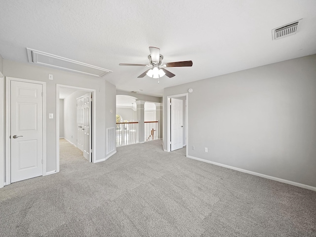 carpeted spare room with ceiling fan and a textured ceiling