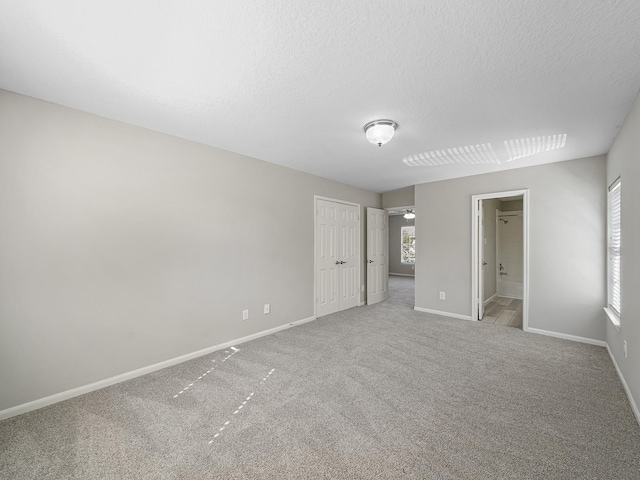 unfurnished bedroom featuring connected bathroom, carpet floors, and a textured ceiling