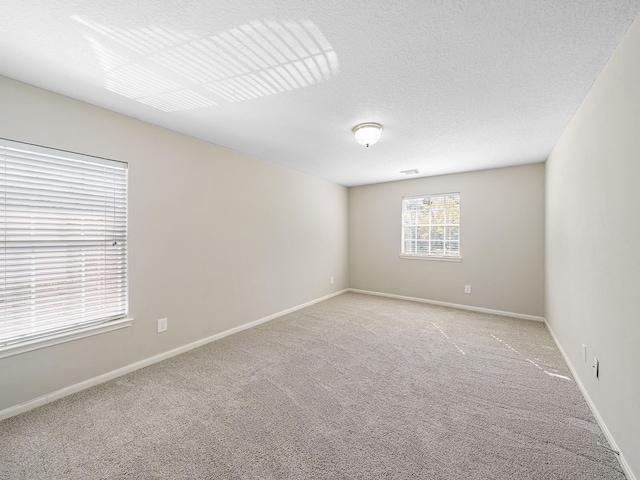 carpeted spare room with a textured ceiling