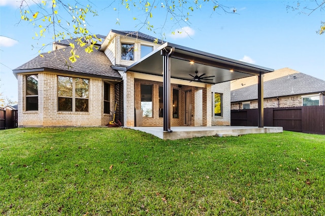 rear view of house with a fenced backyard, a lawn, a patio, and brick siding