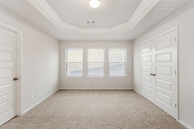 unfurnished room with carpet, a raised ceiling, visible vents, and baseboards