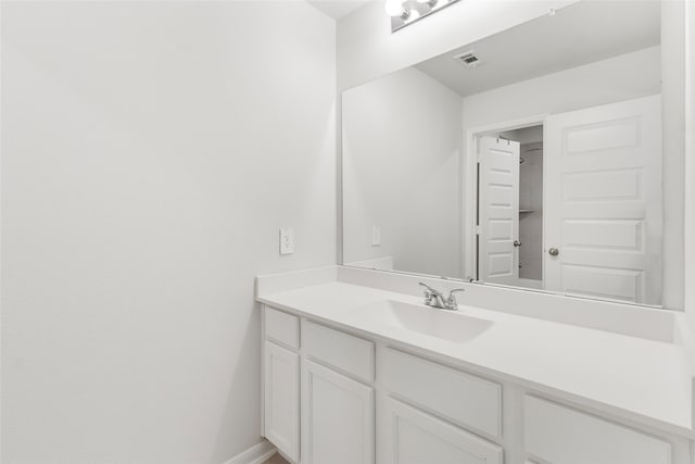 bathroom featuring visible vents, vanity, and baseboards