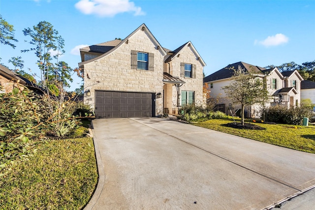 view of front facade with an attached garage, stone siding, a front lawn, and concrete driveway