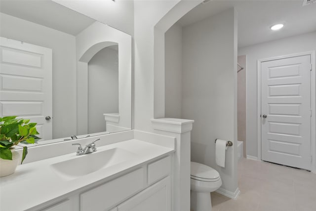 bathroom featuring baseboards, toilet, tile patterned floors, vanity, and recessed lighting