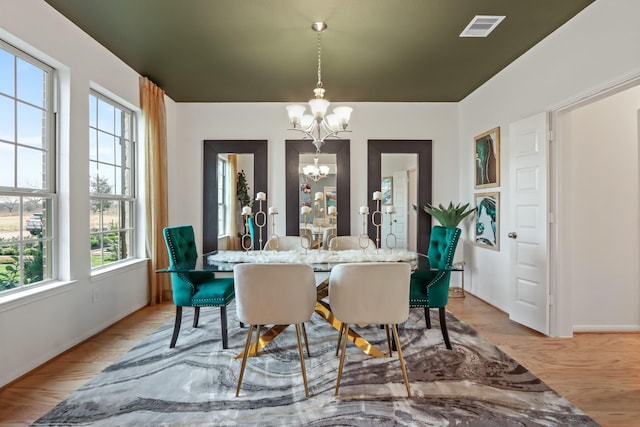 dining space featuring light hardwood / wood-style flooring and a chandelier