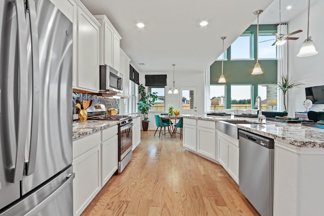 kitchen with plenty of natural light, white cabinets, and appliances with stainless steel finishes