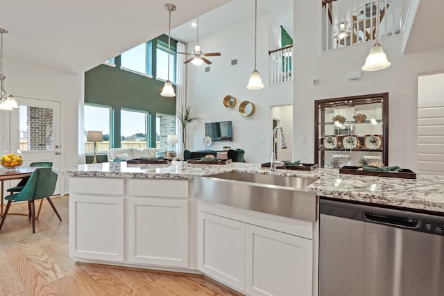 kitchen featuring white cabinetry, dishwasher, a high ceiling, and light wood-type flooring