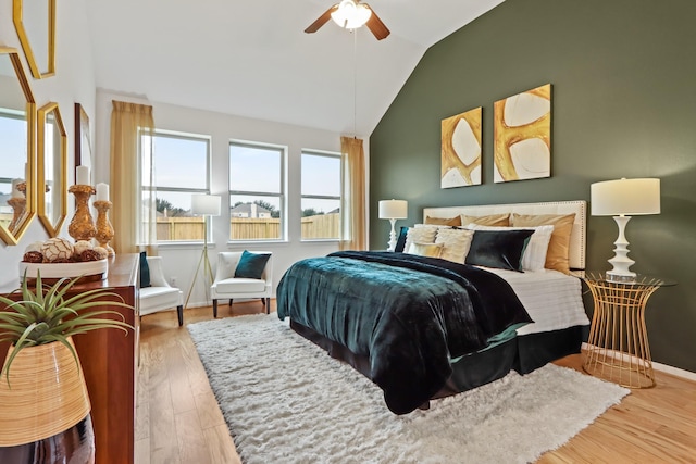 bedroom with ceiling fan, wood-type flooring, and lofted ceiling