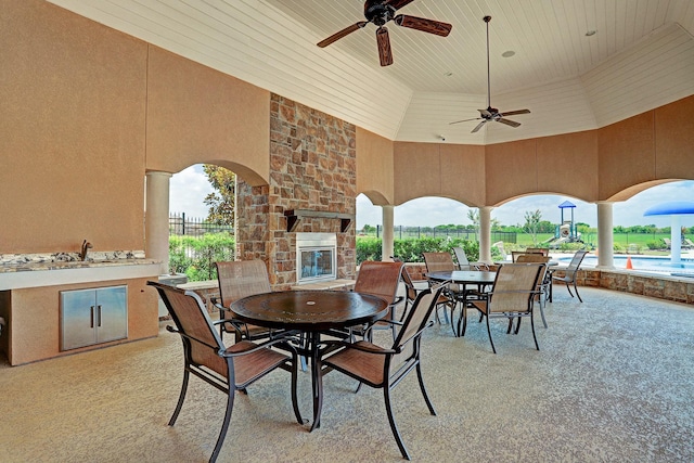 view of patio / terrace featuring an outdoor stone fireplace and ceiling fan